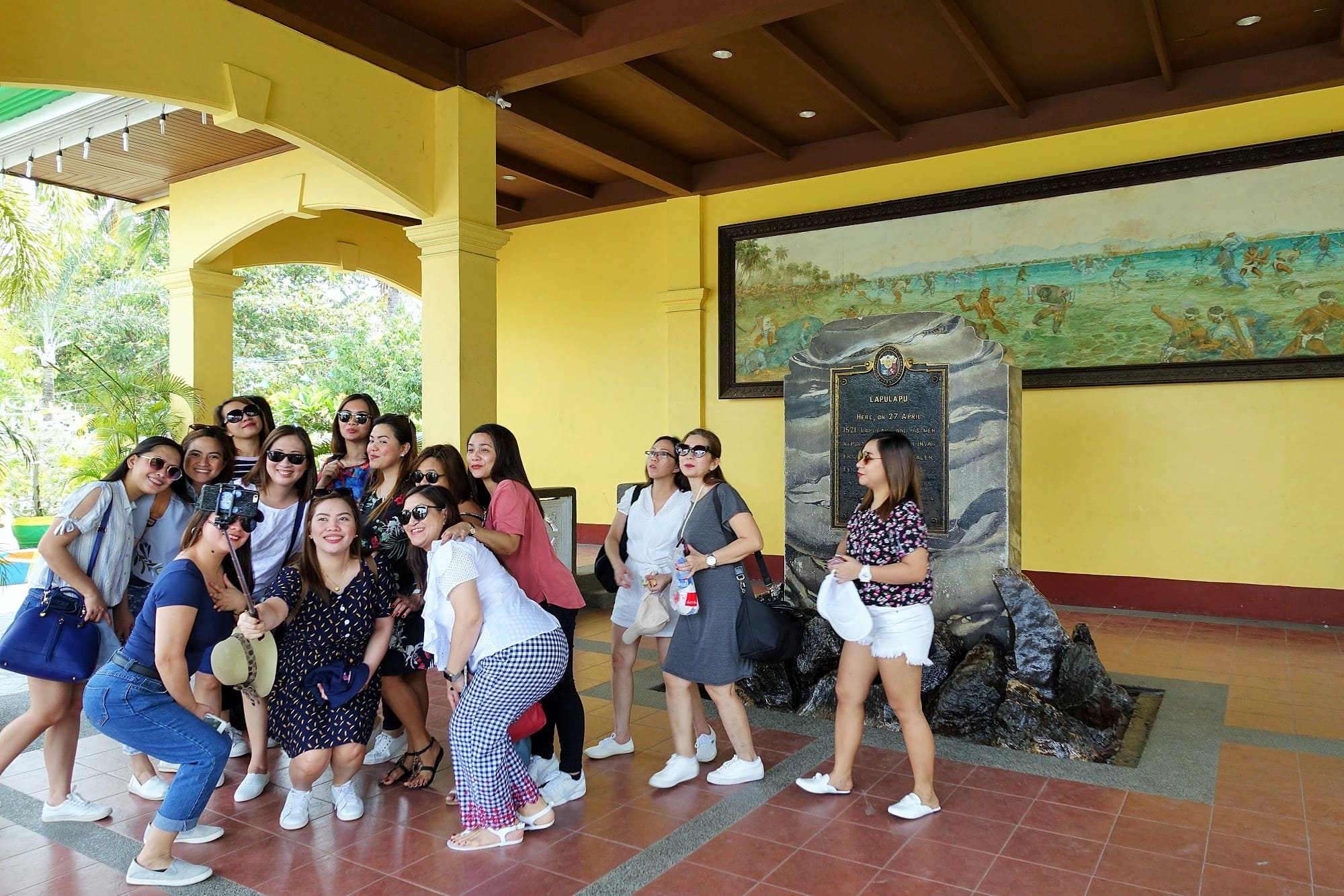 マクタンシュラインの戦勝の碑前で記念撮影をするフィリピン人観光客
